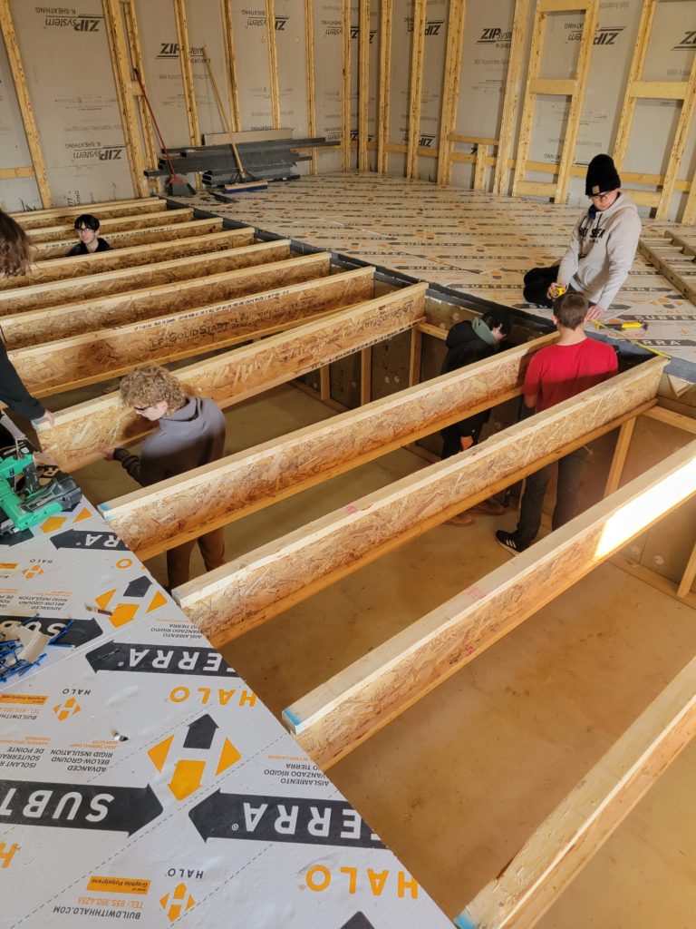 Students of Taylorville High School Building Trades Program in Taylorville, IL framing out the floor of the house they're building during this course.
